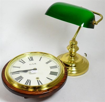 Lot 288 - A reproduction GNR wall timepiece and a brass desk lamp of similar date