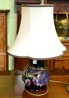 Lot 331 - A Moorcroft pottery table lamp in Anemone pattern on a blue ground, with silk shade