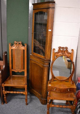 Lot 1084 - A standing oak corner cupboard, a pair of carved high caned backed chairs and a toilet mirror