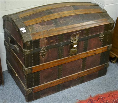 Lot 1131 - An iron and wooden bound dome topped trunk, with leather handles and lined interior