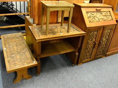 Lot 1144 - A carved oak bureau, matching side table dated 1944, coffee table and a lamp table (4)