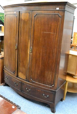 Lot 1149 - An impressive bow fronted double wardrobe fitted with two base drawers