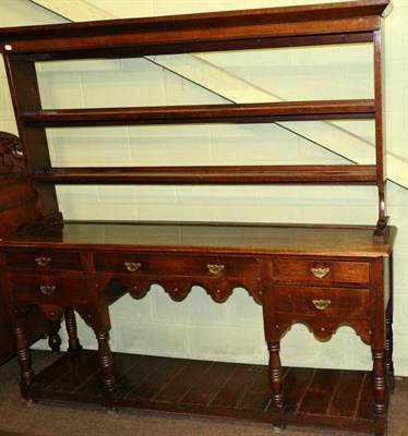 Lot 1248 - A George III oak dresser and rack of small proportions, with pierced scroll carved apron