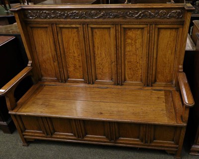 Lot 1299 - A carved oak five panel box settle