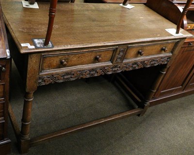 Lot 1366 - An early 20th century carved oak hall table with two drawers raised on gun barrel legs