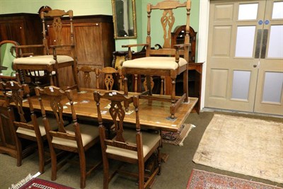 Lot 1373 - A reproduction oak dining suite comprising: a refectory table, a set of eight dining chairs...