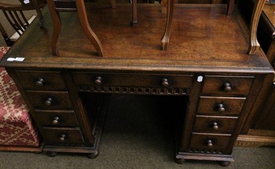 Lot 1377 - A 1920's carved oak leather inset kneehole desk