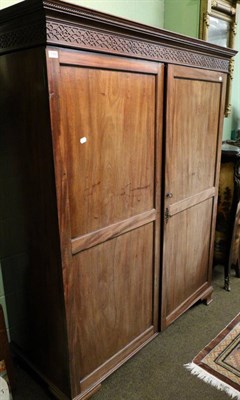 Lot 1382 - A George III mahogany double wardrobe decorated with blind fret-work