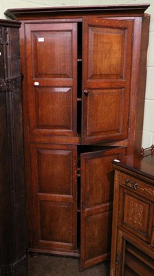 Lot 1386 - A George III panelled oak standing corner cupboard