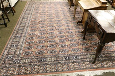 Lot 1418 - A machine made carpet, of Tekke design , the field with columns of quartered guls enclosed by...