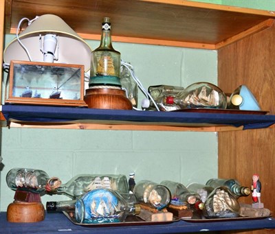 Lot 266 - A collection of approximately twenty ship in bottle models, two formed as lamps (two shelves)