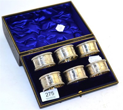 Lot 275 - A cased set of six silver napkin rings