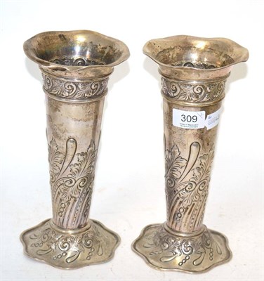 Lot 309 - A pair of silver bud vases decorated with repousse