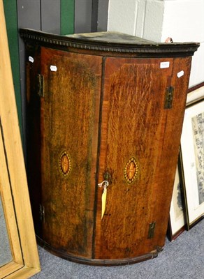 Lot 1083 - A bow fronted corner cabinet