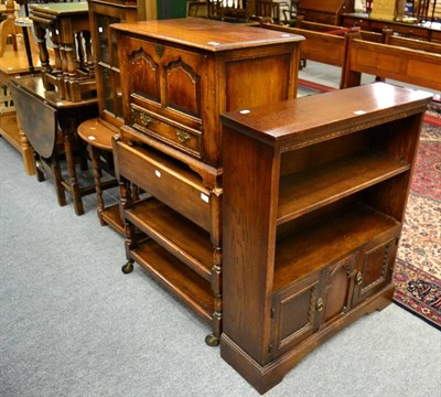 Lot 1110 - A three tier oak trolley, an oak open bookcase and a panelled oak tv cabinet