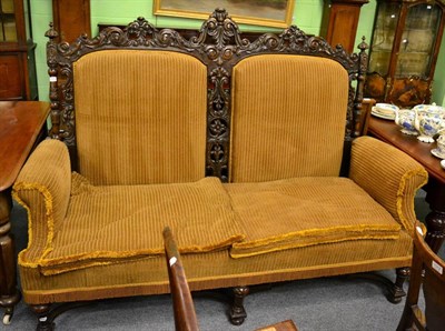 Lot 1305 - A large Victorian carved sofa with yellow upholstery