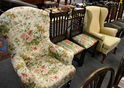 Lot 1329 - A wingback chair together with a pair of oak dining chairs, and a floral upholstered armchair