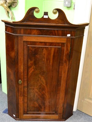 Lot 1363 - A George III mahogany corner cupboard with swan neck pediment