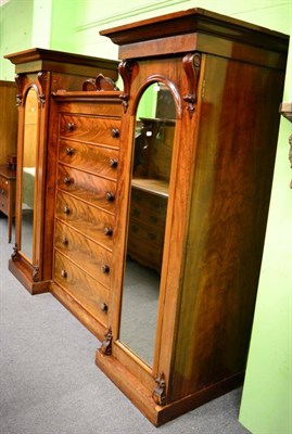 Lot 1365 - An imposing flame mahogany wardrobe, the central six drawer section flanked by twin mirrored doors