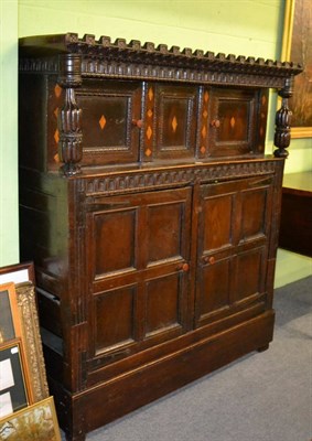 Lot 1387 - A 17th century inlaid oak court cupboard, the castellated cornice above two inlaid panelled...