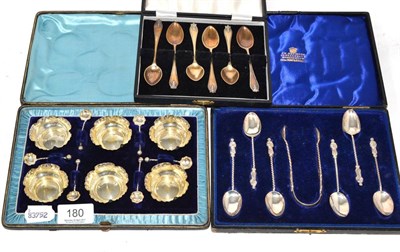 Lot 180 - A set of six cased silver salts and spoons, a set of six cased Gospel spoons, a pair of sugar tongs