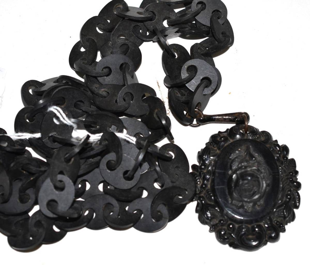 Lot 312 - A Victorian bog oak pendant on a vulcanite chain