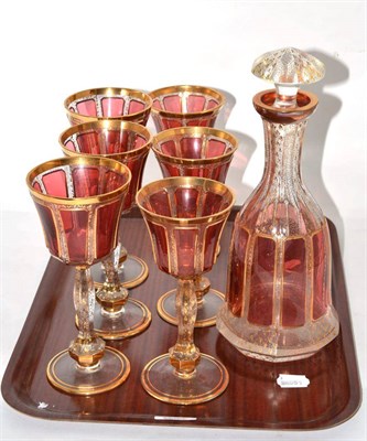 Lot 348 - A set of gilt highlighted cranberry glass wines together with a matching decanter
