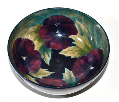 Lot 363 - A William Moorcroft Pansy bowl, impressed factory mark and green painted signature (restored rim)