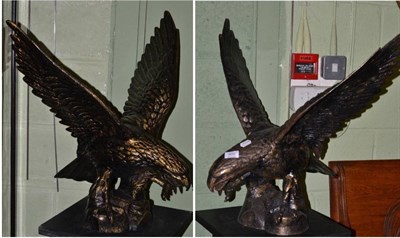 Lot 500 - A pair of patinated metal eagle models on naturalistic bases