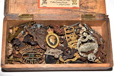 Lot 534 - A small wood box containing assorted military cap badges, shoulder titles, rank pips and buttons