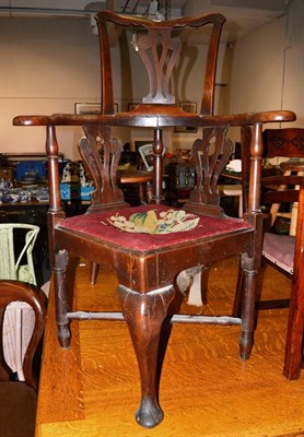 Lot 1066 - An 18th century oak corner armchair with needlework drop in seat