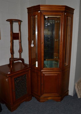 Lot 1112 - A reproduction cherrywood free-standing corner cupboard, with bevelled glass panels enclosing glass