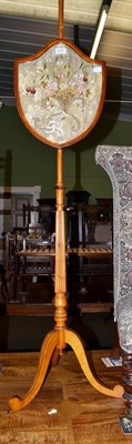 Lot 1215 - A 19th century satinwood polescreen, with embroidered shield form panel, fluted column and...