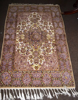 Lot 1278 - A part silk Kashmir rug, the ivory field of scrolling vines around the stellar medallion framed...