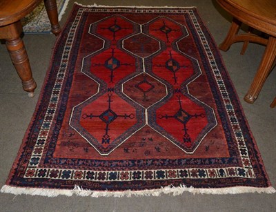 Lot 1291 - A West Persian village rug, the crimson geometric lattice field enclosed by ivory borders, 234cm by