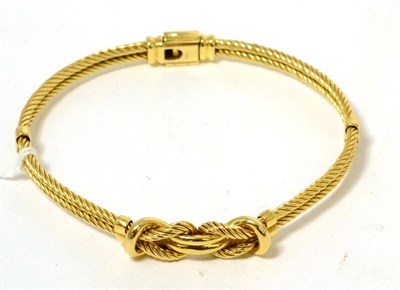 Lot 18 - A fancy rope and knot design bangle, stamped '750'