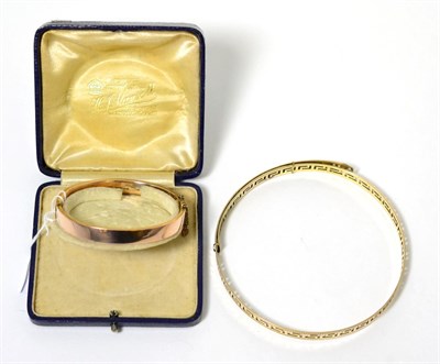 Lot 73 - A 9 carat rose gold hinge opening bangle and a Greek key design arm bangle, stamped '9CT' (2)