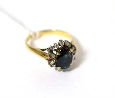 Lot 119 - A sapphire and diamond cluster ring, an oval cut sapphire within a border of eight-cut and baguette