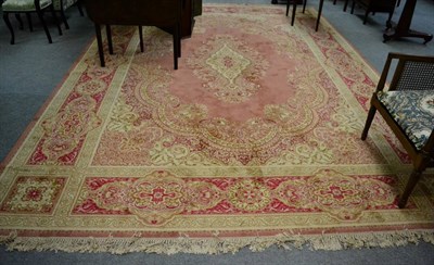 Lot 1234 - A machine made carpet of Kashan design, Eastern Europe, the plain coral pink field with...