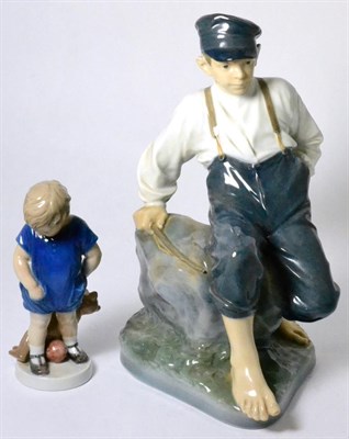 Lot 69 - A large Royal Copenhagen porcelain model of a boy seated on a rock; and a small model of a...