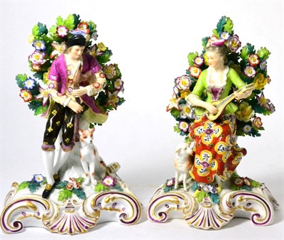 Lot 70 - A pair of Derby style figure groups of musicians, man playing bagpipes accompanied by dog and...