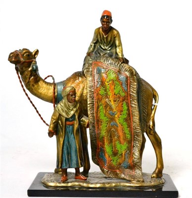 Lot 115 - A cold painted spelter table lighter, modelled as a carpet seller sitting on a camel holding a rug