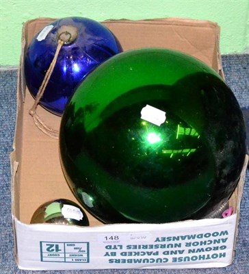 Lot 148 - A large green witches ball, with two smaller blue and silver examples (3)