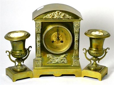 Lot 208 - A 19th century brass clock garniture, the clock of architectural form flanked by a pair campana...