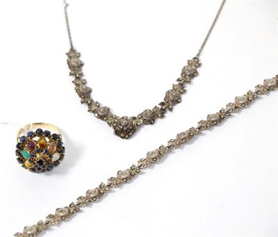 Lot 252 - A sapphire and multi gemstone cluster ring and a marcasite necklace and bracelet set (3)