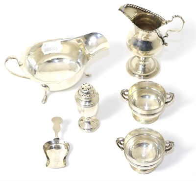 Lot 284 - A group of silver items comprising: a caddy spoon, pepperette, sauceboat, pair of salts and a...