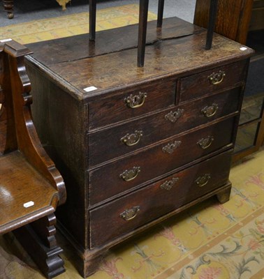 Lot 1051 - A George III small oak four height chest of drawers, on bracket feet