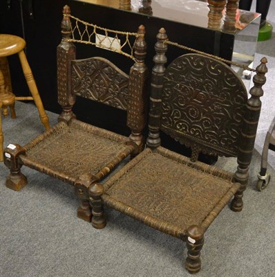 Lot 1167 - A pair of Afghan ceremonial chairs, late 19th/early 20th Century, heavily carved and turned detail