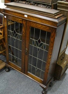 Lot 1176 - A small 20th century oak bookcase with a pair of stained glass doors