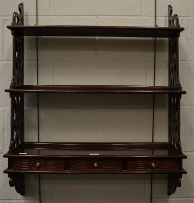 Lot 1188 - A three tier hanging shelf with three base drawers decorated with blind and pierced fret work